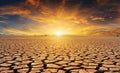 Orange cloudy sunset over cracked desert