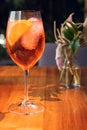 Orange cocktail with orange garnish in wine glass, aperol spritz in sunny setting Royalty Free Stock Photo