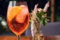 Orange cocktail with orange garnish in wine glass, aperol spritz in sunny setting Royalty Free Stock Photo