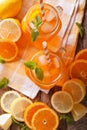 Orange cocktail with ice and mint in a glass jar closeup. Vertical top view Royalty Free Stock Photo