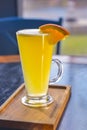 Orange cocktail with orange slice on top. Served in a tall glass over blurred restaurant background. Selective focus Royalty Free Stock Photo