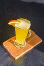 Orange cocktail with orange slice on top. Served in a tall glass over blurred restaurant background. Selective focus Royalty Free Stock Photo