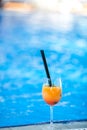 Orange cocktail on swimming pool background.Summer vacation concept. Refreshing beverage.vertical shot. copy space Royalty Free Stock Photo