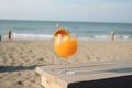 orange cocktail on wooden table and paradisiacal beach with the sea in the background. Copy space. Ai generative
