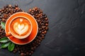 Orange coffee cup with latte art, coffee beans, dark background Royalty Free Stock Photo