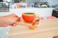 Orange coffee cup in man`s hand. In a coffee shop. Coffee break concept Royalty Free Stock Photo