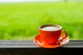 Orange coffee cup with nature bokeh