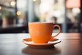 Orange coffee cup, quietly placed on a tabletop