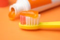 orange color child tooth brush with paste