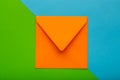 Orange color envelope on green background, as symbol of getting mail, advertisement element.