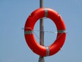 Orange color plastic lifebuoy or life preserver ring mounted on aluminum pole Royalty Free Stock Photo