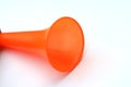 A orange color plastic vuvuzela horn isolated on white background