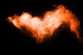 Orange color powder explosion on black background. Mauve orange color cloud.