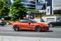 Orange color sportscar Jaguar F type V8 S coupe driving along the street in Moscow