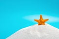 Orange color starfish on white sand on blue concept of summer vacations