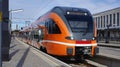 Orange colored regional train waiting on track in main station of Tallinn, Estonia