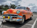 Orange coloured oldtimer parked on the street, Cuba