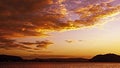 Orange coloured Stratocumulus cloud, sunset seascape. Royalty Free Stock Photo