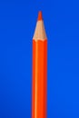 Orange colouring crayon pencil isolated on blue background. Royalty Free Stock Photo