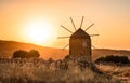 Orange colours of sunset time, one old windmill in the mountains