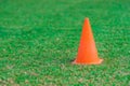 Orange cone standing on a green grass soccer field. Royalty Free Stock Photo