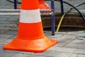 Orange cones installed around the dangerous area on the sidewalk. An open travel hatch. Laying of a new fiber-optic cable in the Royalty Free Stock Photo