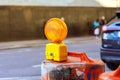 Orange construction warning a lights on barricade in road street under reconstruction