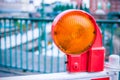 Orange construction warning street barrier light on barricade. Road construction on the streets of European cities Royalty Free Stock Photo