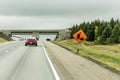 Orange construction worker sign at road into the distance on trans canada Royalty Free Stock Photo