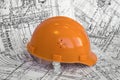 Orange constructional helmet and project drawings. Royalty Free Stock Photo