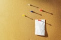 Orange Cork board with one bulletin paper note pinned and several different color pins above. Warm sunlight from the side Royalty Free Stock Photo