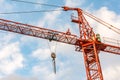 Orange crane in a day of blue skies and with clouds