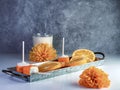 Orange Creamsicle cake pops arranged on a rustic metal tray with fresh sliced oranges and a glass of milk with orange flowers and