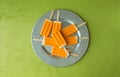 Several orange creamsicles on a galvanized steel plate. Directly above on green background with copy space.
