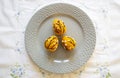 Orange crocheted Easter eggs on a plate on a white tablecloth. Easter handmade