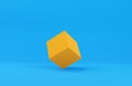 Orange cube box primitive geometry on blue background with copy space, modern minimal concept