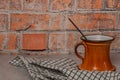 Orange cup with fragnant stick and red brick wall background