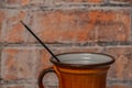 Orange cup with fragnant stick and red brick wall background