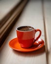 Orange cup of fresh brewed hot coffee on a wooden table. Royalty Free Stock Photo