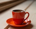 Orange cup of fresh brewed hot coffee on a wooden table. Royalty Free Stock Photo