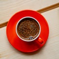 Orange cup of fresh brewed hot coffee on a wooden table. Royalty Free Stock Photo