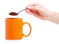 Orange cup mug with spoon coffee in hand