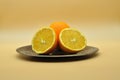 An orange cut in half and a whole orange placed on an elegant and antique silver plate Royalty Free Stock Photo