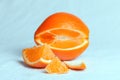 Orange cut into pieces on a bluish background