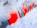 Orange cylinder construction under snow