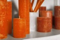 Orange cylindrical candles on a shelf apartments decor