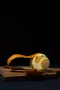 Orange on a dark background. Peeled orange and knife on a black background. Royalty Free Stock Photo