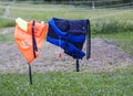 Orange and dark blue life jackets drying on the rope outdoors Royalty Free Stock Photo