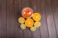 orange detox coctail with half orange,lemon and lime lies on tab