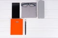 Orange diary with a pen, glasses on cloth for rubbing and mobile Royalty Free Stock Photo